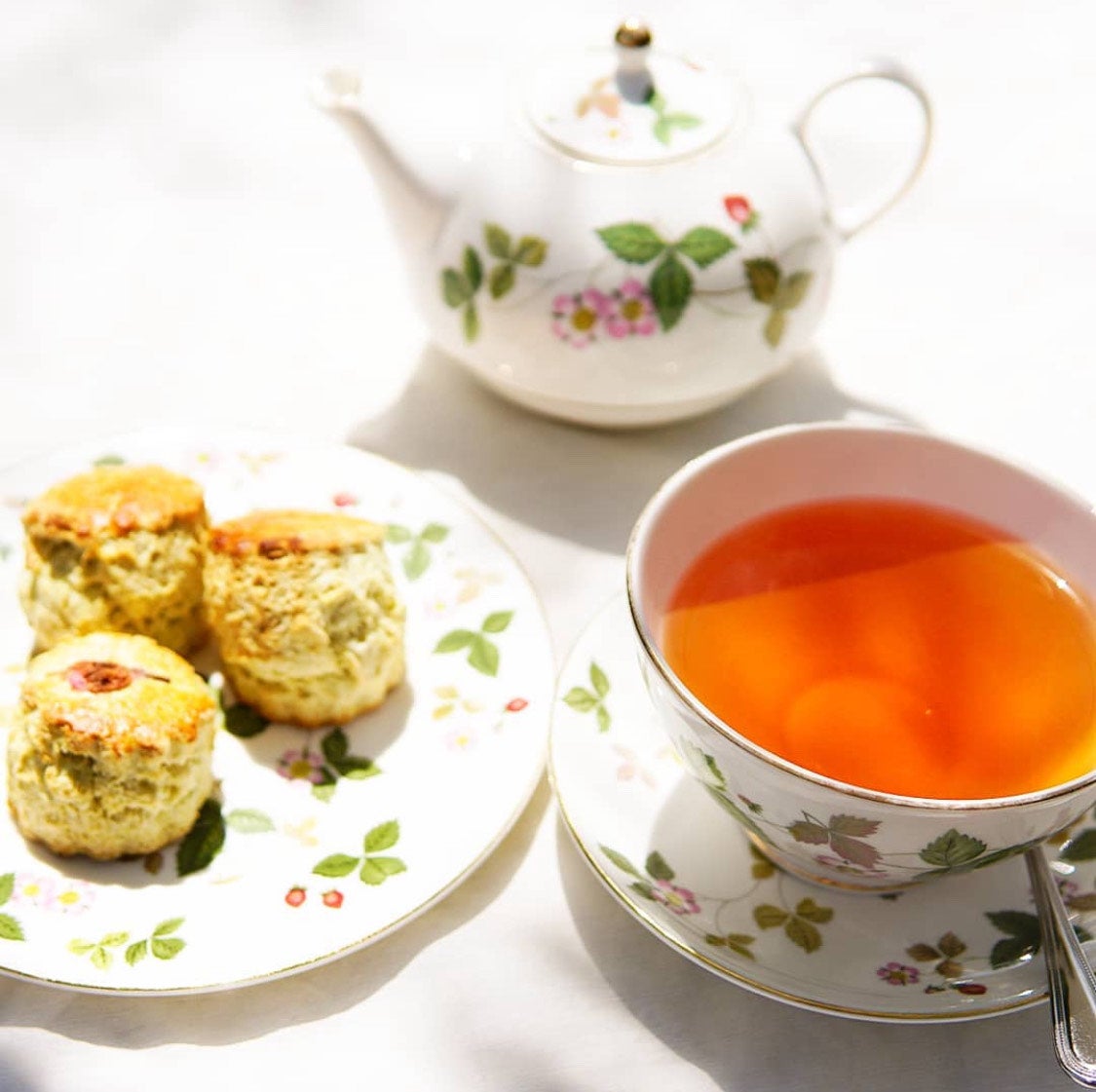 紅茶とスコーン、ティーポットのあるテーブルセッティング